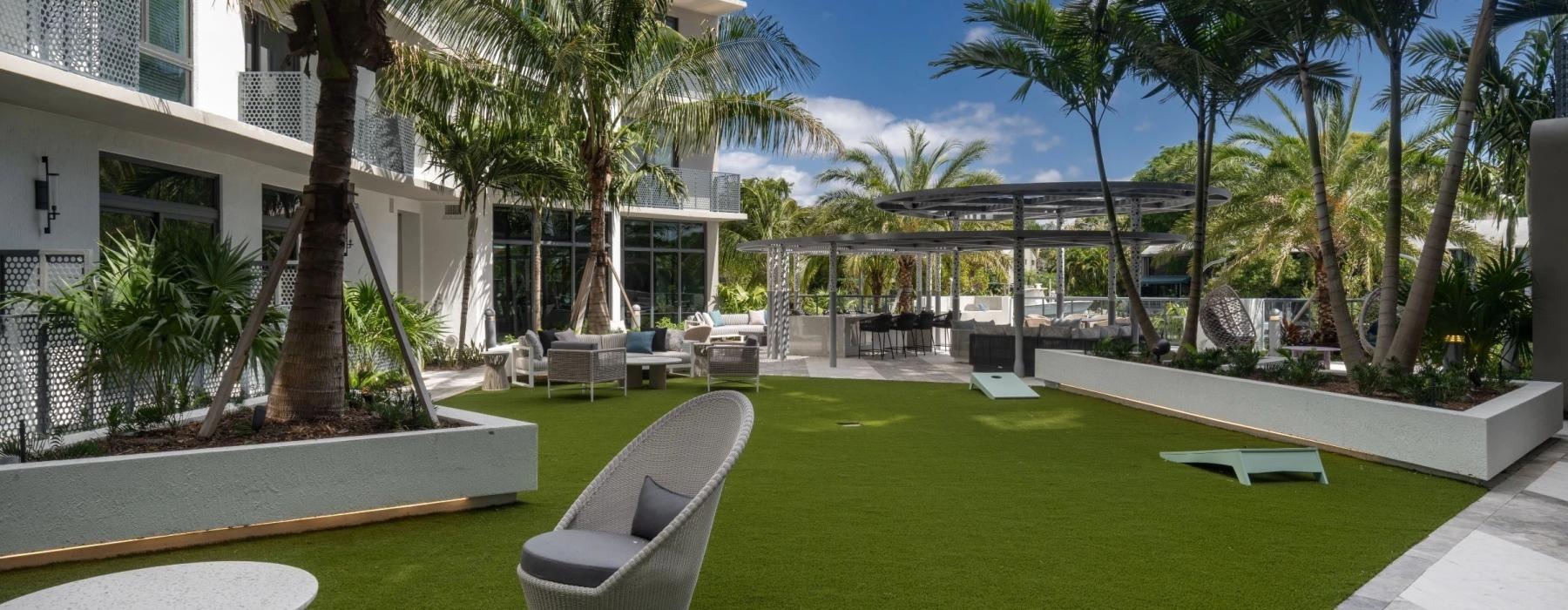 a building with palm trees and a lawn