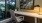 a room with a desk and chair by a window