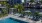 a pool with chairs around it by a body of water